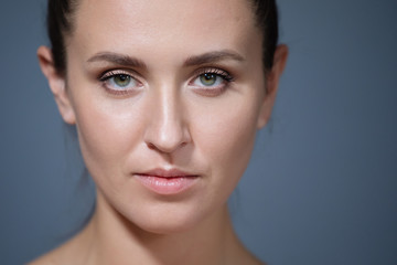 Large portrait of a beautiful girl on a gray background.