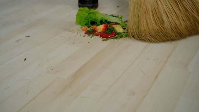 someone sweeping the floor in the kitchen