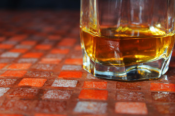 Glass of scotch whiskey on dark background