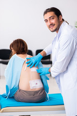 Injured young woman visiting young male doctor