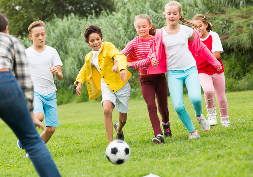 Cheerful children are jogning with ball