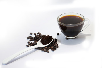 coffee beans, ground coffee, black coffee in a glass on a white background