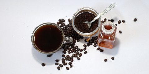 Black coffee in glass, ground coffee and coffee beans in glass jar on white background. Top view, space for text.