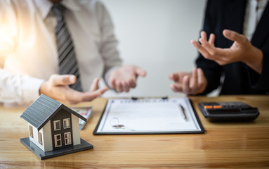 Real estate broker agents advise clients to make a decision to buy a house with insurance. Negotiating purchase-sale and investment planning concept.