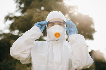 Portrait of doctor epidemiologist fighting with coronavirus COVID-19. Protection mers by virologist. White medical suit with mask, gloves, glasses. Face of global crisis during epidemic.