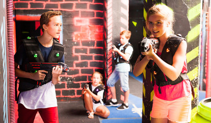 Fototapeta na wymiar Girls and boys playing laser tag