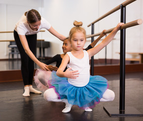 Ballet trainer teaching two little girls