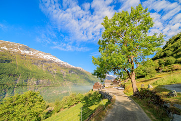 Fototapeta na wymiar GEIRANGER, NORWAY - 2016 JUNE 13. The narrow road to Westeras farm and restaurant with view over Geiranger fjord and mountains.