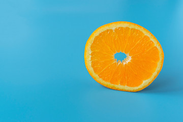 Ripe juicy orange on a blue background. Citrus fruit. Vitamins and Food for Vegetarians..