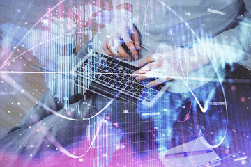 Double exposure of businessman working on laptop on background. International business hologram in front. Concept of success.