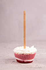 Strawberry ice cream popsicle lollies with whipped cream frozen in muffin molds on gray background.