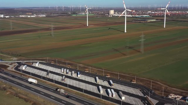 Flying towards a truck stop on A4 autobahn a part of E60 road on Austria Hungarian border with wind turbines on background during quarantine