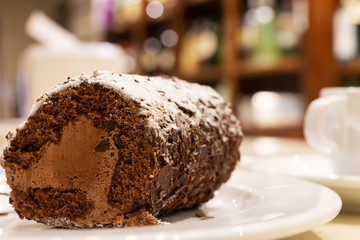Chocolate roll cake and truffle decorated with sheets of chocolate and icing sugar