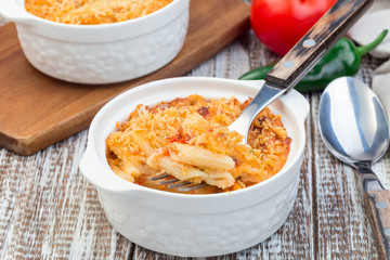 Spicy tomato jalapeno mac and cheese with mini penne pasta, in baking dish, closeup, horizontal