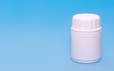 White medical bottle vial on a blue background.Copy space for text