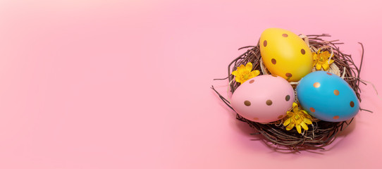 Fototapeta na wymiar Easter eggs in nest on pink background.Copy space for text