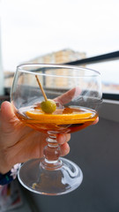 Vermut en copa de balón con olivas y naranja