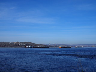 Fototapeta na wymiar Cargo ships stand in the roadstead on the Volga River near Saratov