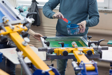 Silk screen printing. Serigraphy. Color paints and fabric. Carousel machine.