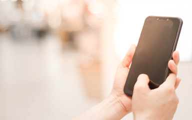 Woman hands holding smart phone with blank blank screen for text message or information content,