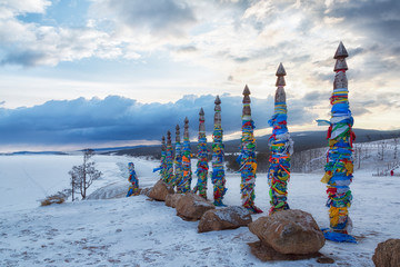 Wooden ritual pillars with colorful ribbons on cape Burkhan, Lake Baikal, Olkhon, Russia