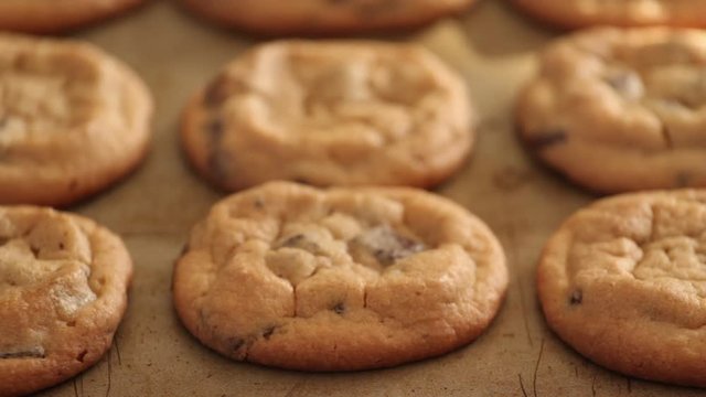 Slow pan footage of chocolate chip cookies on baking sheet
