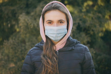 Attractive Girl Takes on Medical Mask. Breathes deeply and looking at camera on green background. Health care and medical concept