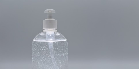 Sanitizer hydrogel filled pump bottle dispenser for the hand hygiene, isolated on gray background, with space for text