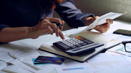 Stressed young woman checking bills, taxes, bank account balance and calculating expenses in the living room at home - Powered by Adobe