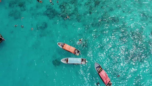 Aerial frone fly by the Tropical paradise Mnemba Island, located 3 km off the coast of Zanzibar's main island Unguja. Lent of Dhow Boats with divers came for snorkeling tour