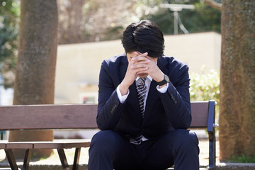 心配事で悩む日本人男性ビジネスマン