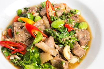 spicy stir fired beef oyster sauce with pepper seeds kaffir lime leaves sato and paprika chili serve on white plate