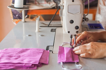 Handmade mask sewing from the fabric is used to prevent spread disease outbreaks from coughing or sneezing with dust in the air and germs close-up.