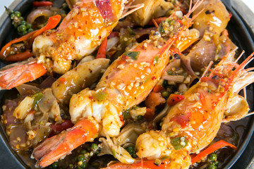 big prawns top with hot and spicy sauce serve in hot plate close up shot