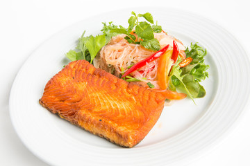 grilled salmon salad serve with mixed clear noodle coriander decorate by parsley and chili serve in white plate isolated white background