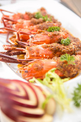 big prawns grilled top with thai hot and spicy sauce serve in white plate