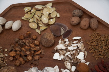 Chinese medicine and herbs are in wooden trays, they are in a white background. Chinese prescription close-up Top view