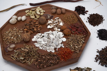 Chinese medicine and herbs are in wooden trays, they are in a white background. Chinese prescription close-up Top view