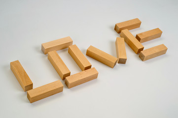 The word Love laid out by wooden blocks on a white background. Background for love and romance.