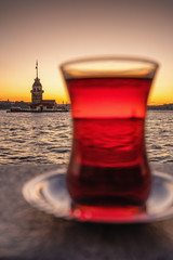 Traditional turkish tea in a glass with Maiden Tower at background in Istanbul, Turkey