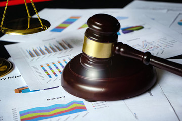 Blurred of wooden judge gavel put on business paper chart,Lens flare effect