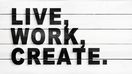 Live, work, create, motivation and inspiration slogan, black text on white wood planks