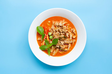 Panaeng Curry with pork in white bowl on blue background. Copy space