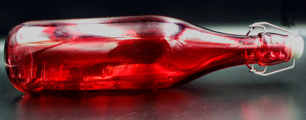 panoramic red glass bottle with stopper isolated on a black background