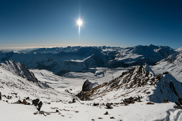 amazing views of snowy mountains, clear blue sky and sun