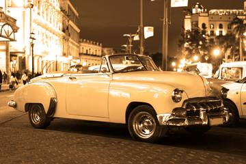 classic american convertible car in havana by night black and white sepia look