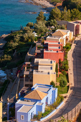 Multicolored houses with gardens, roofs and terraces by the sea near Agios Nikolaos on the island of Crete in the Aegean sea, Greece, Europe.