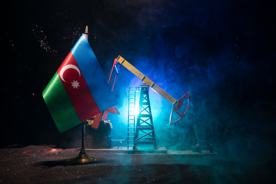 Business dialogue, oil agreement concept: National flags with Oil pump and oil refining factory at night with fog and backlight. Energy industrial concept.