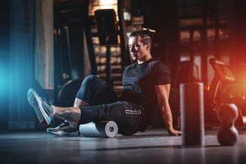 young man has crossfit workout with roller and weight in gym