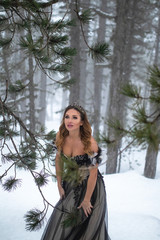 Model cosplay Snow Queen outdoor in winter pine forest